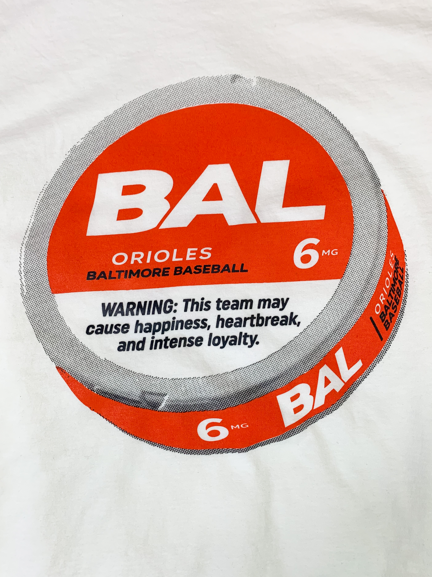 A close-up image of a white short-sleeve T-shirt with a crewneck and a relaxed fit. The front of the T-Shirt features an illustration of a ZYN cannister in black and orange.
This shirt is made from soft ring-spun cotton for comfort and durability.